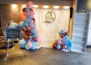 blue, pink and red balloons with backdrop and sign