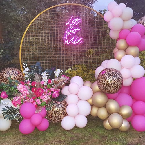 Backdrop with pink and gold balloons and neon sign